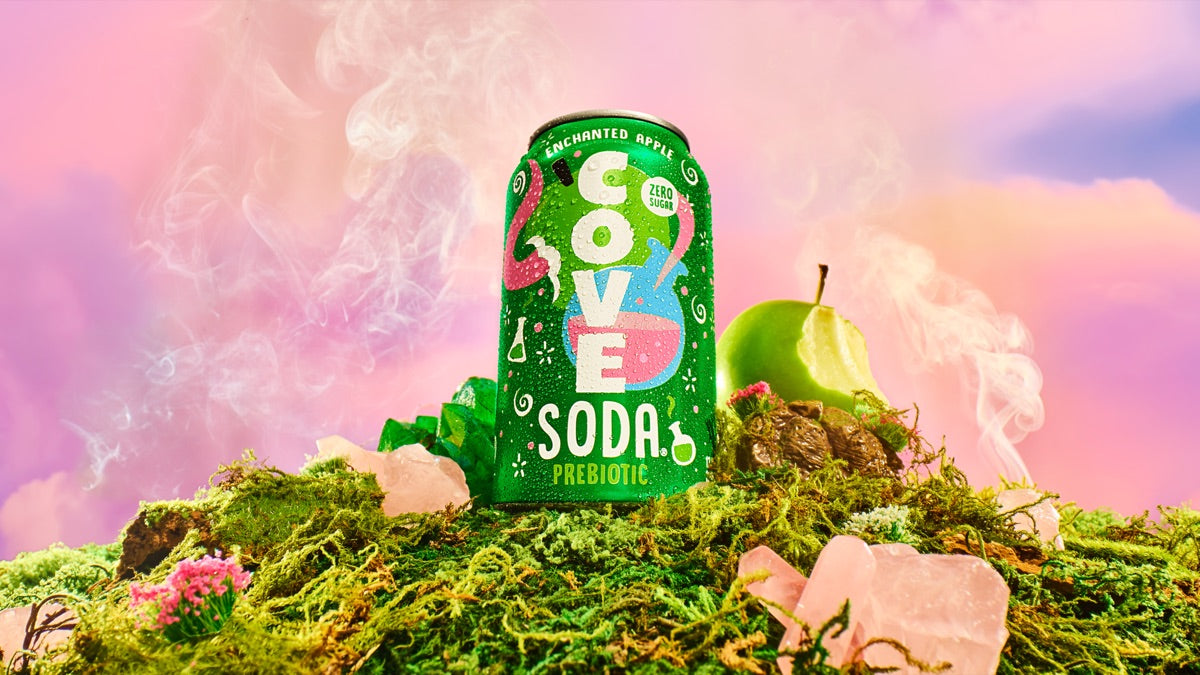 Cove Enchanted Apple can on a mossy mound with a green apple, rose-quartz crystals and pink mist
