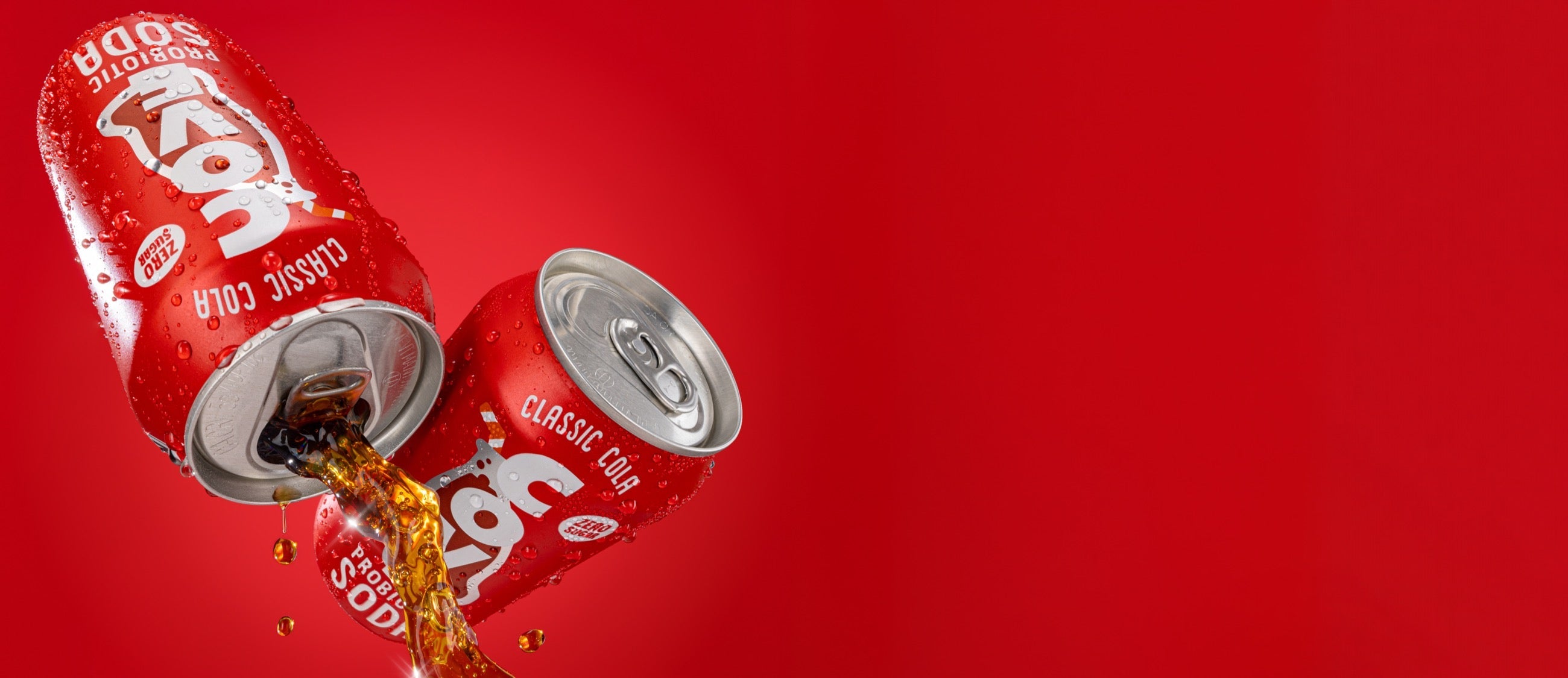 Two Cove Classic Cola cans pouring against a red background